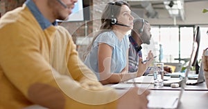 Caucasian businesswoman talking on phone headset sitting on her desk at office