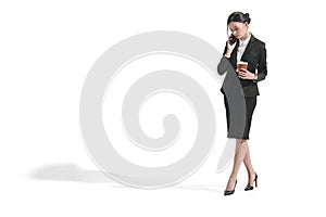 Caucasian businesswoman talking on smartphone while holding paper coffee cup