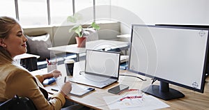 Caucasian businesswoman in wheelchair using laptop and computer with copy space, in slow motion