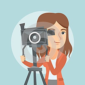 Caucasian cameraman with movie camera on tripod.