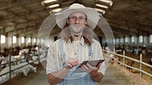 Caucasian cattleman using digital tablet on goat farm