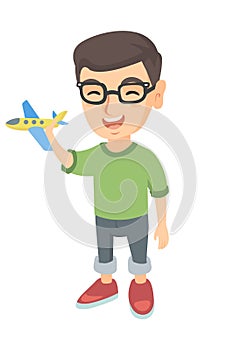 Caucasian cheerful boy playing with a toy airplane