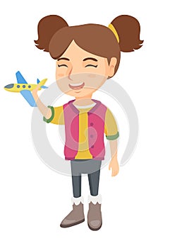 Caucasian cheerful girl playing with toy airplane.