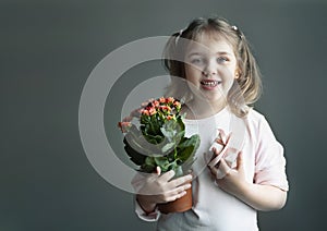 caucasian child girl holding pot with plant and gift box, little kid portrait empty copy space holiday design, female with