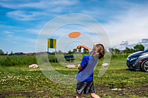 Caucasian child playing disc golf and making the first toss