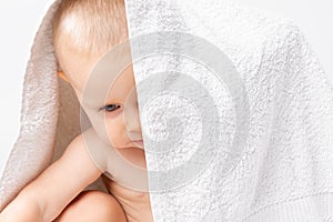 Caucasian child with a towel on his head. White background.