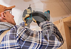 Contractor Assembling Drywall Board Using Drill Driver