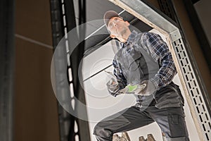 Caucasian Construction Site Worker Patching a Drywall photo