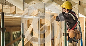 Construction Worker and Newly Built Wooden Roof Frame