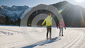 Caucasian couple cross country skiing on snow trails in a ski resort