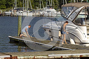 A caucasian couple is docking their Cabin cruiser boat