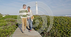 Caucasian couple enjoying free time by sea on sunny day walking path
