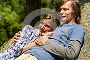 Caucasian couple enjoying sunshine lying on rock