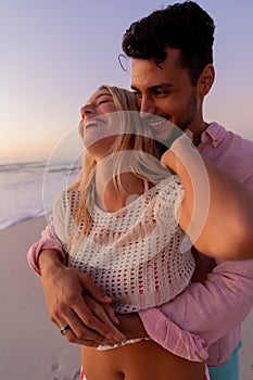 Caucasian couple enjoying time at the beach during the sunset