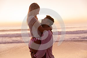 Caucasian couple enjoying time at the beach during the sunset