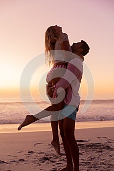 Caucasian couple enjoying time at the beach during the sunset