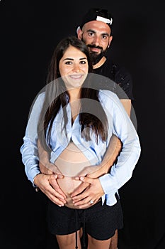 Caucasian couple expecting baby smiling cheerful on background black