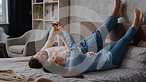 Caucasian couple family woman wife and man husband lying upside down on cozy bed in bedroom relax together rest weekend