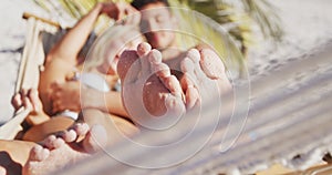 Caucasian couple lying on a hammock on the beach