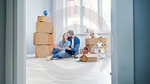 Caucasian couple moving in new home. Young stylish couple in moving in mess.