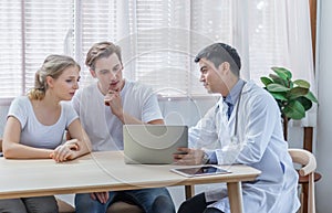Caucasian couple patient husband and wife visit or meeting male doctor for pregnanct consultation at clinic or hospital. Lover