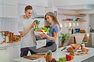 Caucasian couple preparing salad for dinner together in kitchen