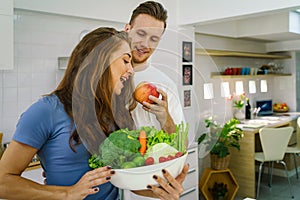 Caucasian couple preparing salad for dinner together in kitchen