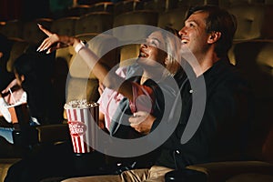 Caucasian couple with smiling face watching funny movie in movie theater