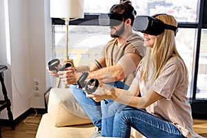 caucasian couple wearing Visual reality or VR headset playing video console game