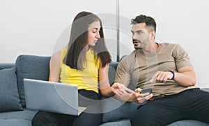 Caucasian couple working on laptop and smartphone