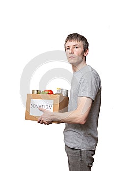 Caucasian courier worker, volunteer holding grocery food in carton donation box