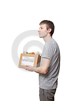 Caucasian courier worker, volunteer holding grocery food in carton donation box