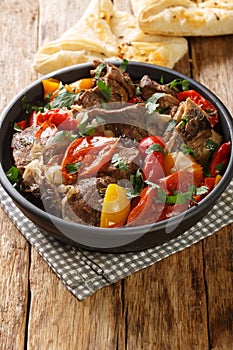 Caucasian cuisine Buglama lamb stewed with vegetables and herbs close-up in a bowl. vertical