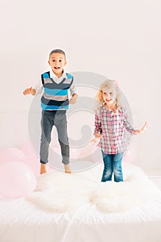 Caucasian cute adorable funny children jumping on bed