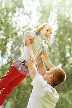 Caucasian dad and young daughter playing together in summer park