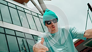 Caucasian dancer looking at camera while dancing at sky scrapper. hiphop.