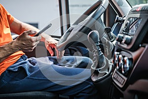 Delivery Truck Driver Browsing Internet Using His Smartphone