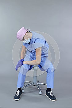 Caucasian dentist with lower back pain sitting on saddle