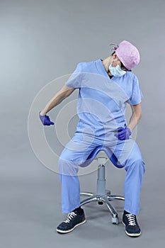 Caucasian dentist sitting on saddle   stretching arm and hand