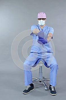 Caucasian dentist sitting on saddle   stretching arm and hand