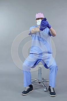 Caucasian dentist sitting on saddle   stretching arm and hand