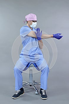 Caucasian dentist sitting on saddle   stretching arm and hand