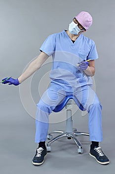 Caucasian dentist sitting on saddle   stretching arm and neck