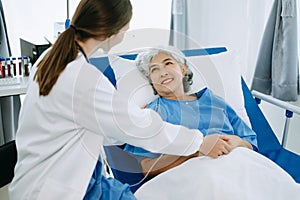 Caucasian doctor smiling take care of a senior patient in hospital. Friendly nurse or therapeutic treat client Professional