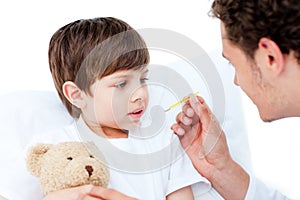 Caucasian doctor taking little boy's temperature