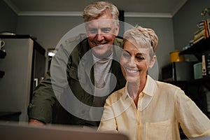 Caucasian elderly couple looking at laptop screen