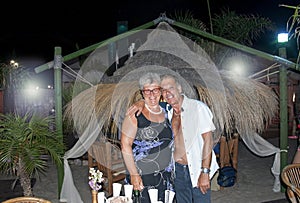 Caucasian elderly couple posing embraced for a portrait at a night party. Anniversary.