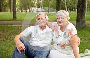 Caucasian elderly couples sit and relax together in the park