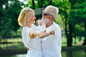 Caucasian  Elderly man and woman  happy  smiling dancing  in the park