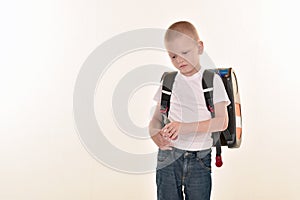 A caucasian elementary age boy posing in uniform and baccpack isolated on white background. School and education concept